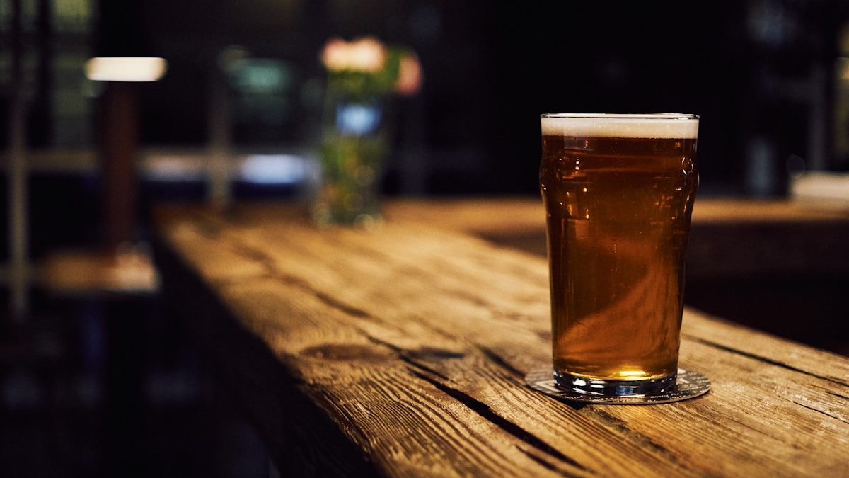 Draft craft beer pouring from taps into cold pint glasses