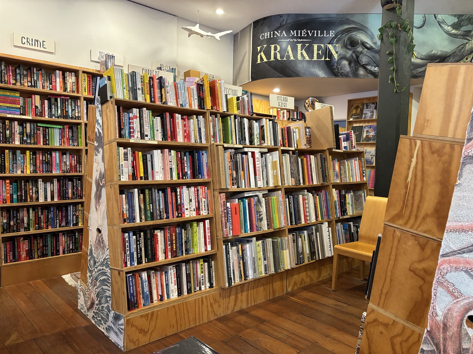 Bookstore staff unpacking publisher book cartons and sorting books onto categorized shelves