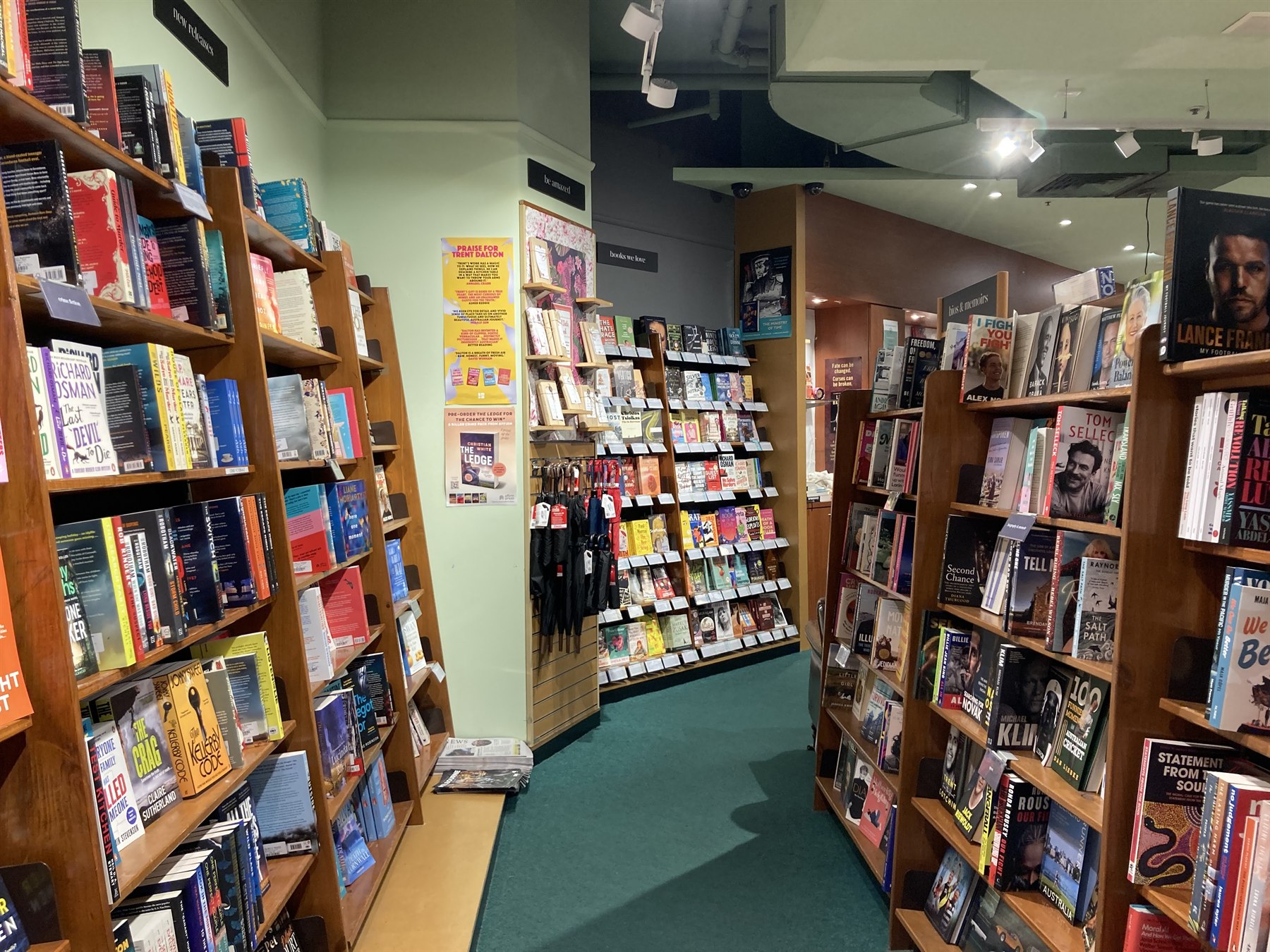 Modern bookstore interior with organized wooden bookshelves packed with books and bestsellers